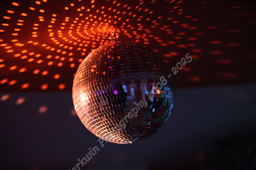 IMG 7172sl 
 Disco ball shining with red and orange reflections on ceiling 
 Keywords: disco ball, red and orange reflections